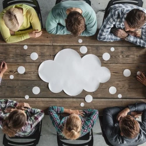 Image of people around a table in a meeting for steps for planning a meeting section.