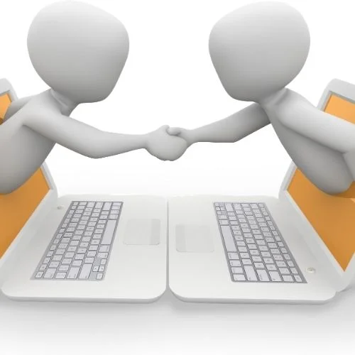 Image of two people reaching through a computer shaking hands for digital meeting services section.