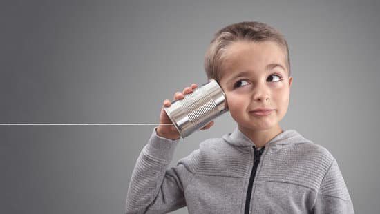 Image of a boy listening into a can attached to a string to represent listening to improve communication skills, master communication skills.