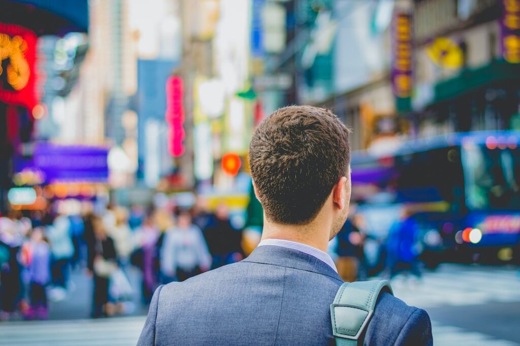 Man in a suit looking at a busy street ready to embark on journey of a career vs job.