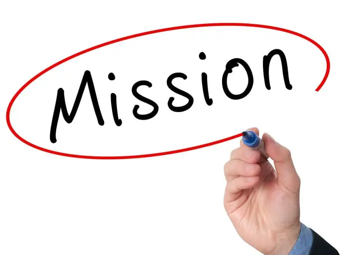 image of a person's hand writing mission for what is a personal mission statement.