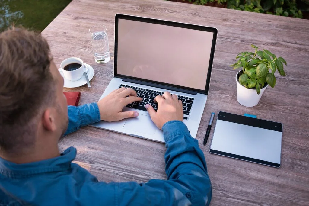 Man working on a laptop in a hybrid workplace.