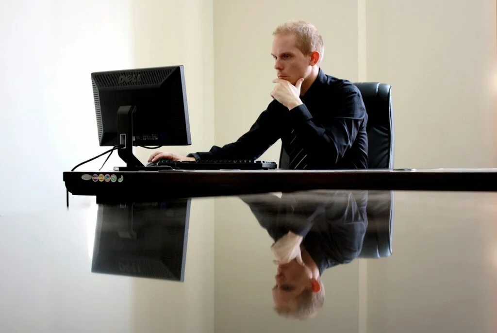 Man sitting at desk thinking about forward-thinking leadership