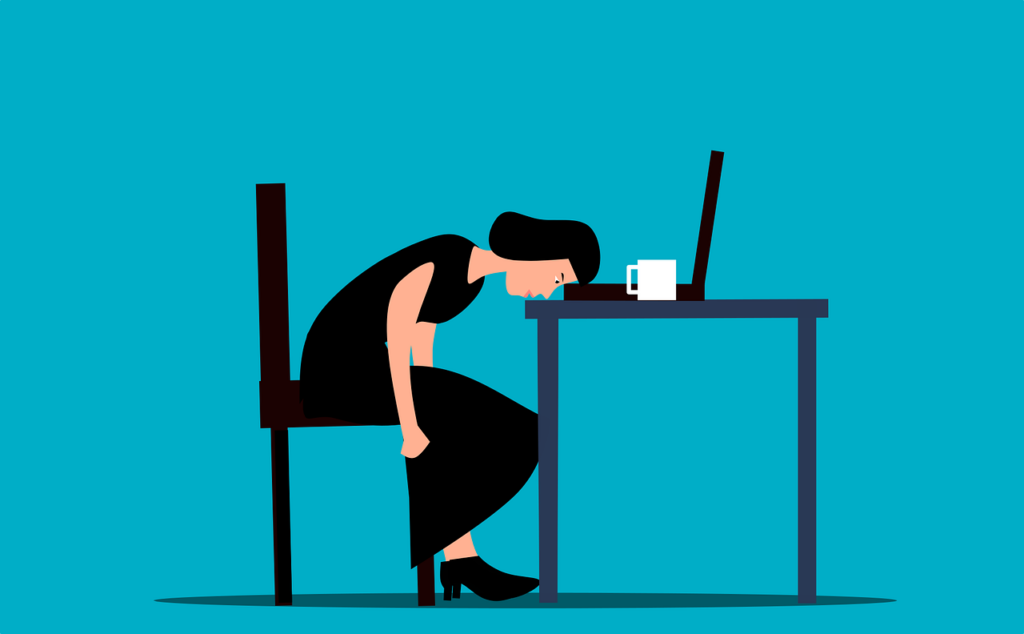 Woman at her desk dealing with burnout from her job.